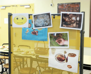 Tableau d'affichage avec un smiley qui ne sourit pas et composé d'images accrochées sur la thématique de l'alimentation